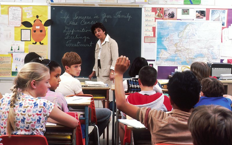 Dedicated teacher and pediatric speech specialist working empathetically with young autistic child